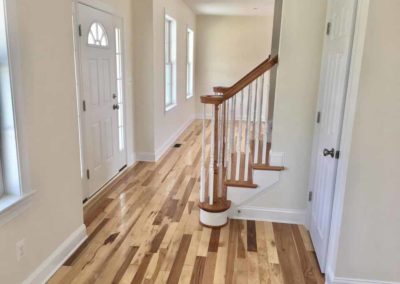 Interior of home with wood flooring and wooden staircase steps by Hauptman Builders