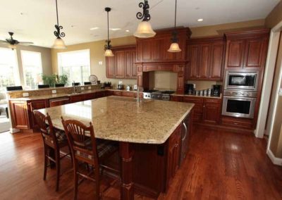 Kitchen with mahogany wood cabinets and flooring by Hauptman Builders